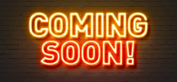 Coming soon neon sign on brick wall background. 