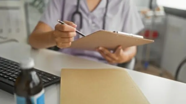 person checking clipboard versus computer