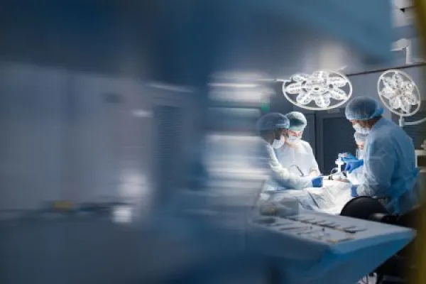 Operation room surgery in hospital, blurred figures.