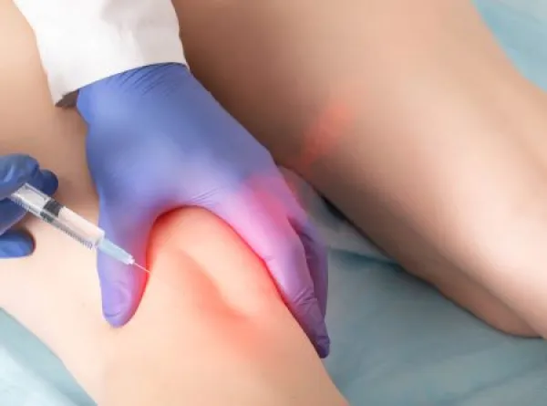 Downloaded A doctor in the clinic performs a procedure for blocking the tibial nerve under the knee joint.