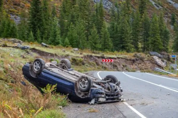 Car accident place on a bend, overturned car lies on the roof