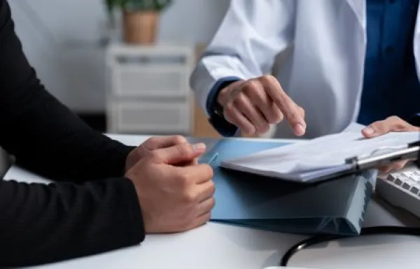 Doctor reviewing medical records with a patient during consultation