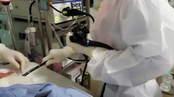 Gastroscopic examination by physician wearing white grown