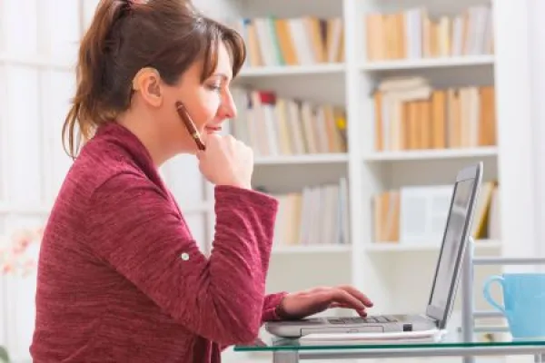 Hearing impaired woman working with laptop 