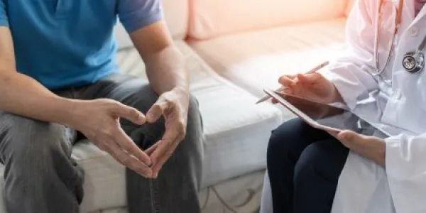 Male patient having consultation with doctor or psychiatrist who working on diagnostic examination