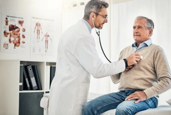 Consultation, man and doctor in office with stethoscope, checkup and healthcare at senior clinic.