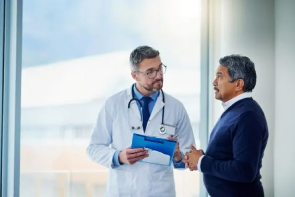 Consultation, medical and doctor talking to patient and writing notes on a clipboard for diagnosis in a clinic.