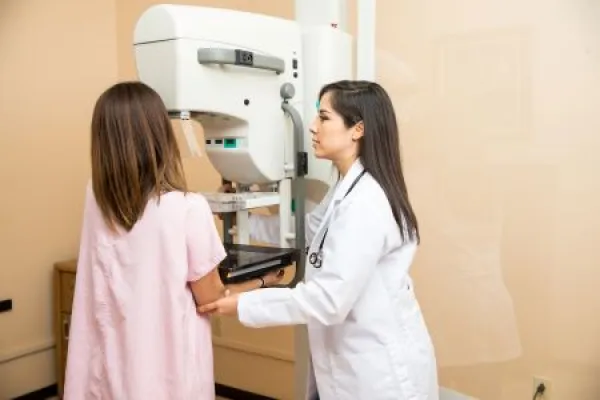 Doctor helping patient get a mammogram in a hospital 