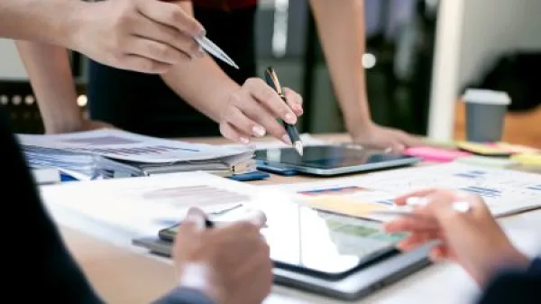 Close-up of business people hands pointing at data charts