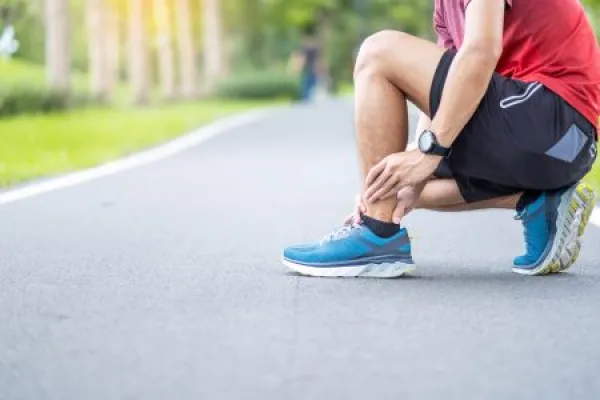 Young adult male with his muscle pain during running. runner man having leg ache due to Ankle Sprains or Achilles Tendonitis. 