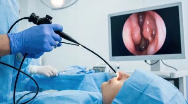 Surgeon performs nasal endoscopy procedure using advanced medical equipment and monitor