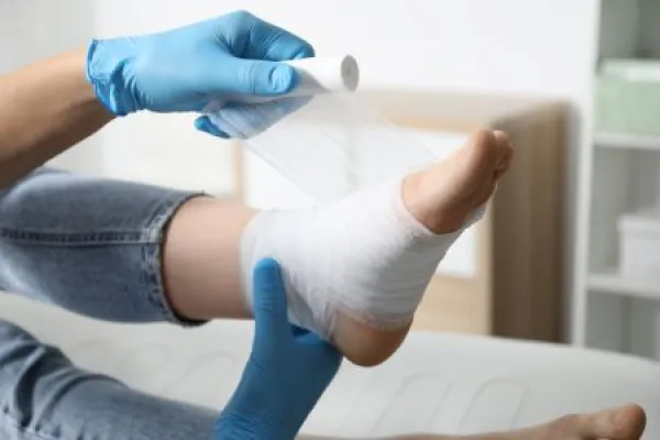 physician bandaging patient’s foot in podiatry clinic