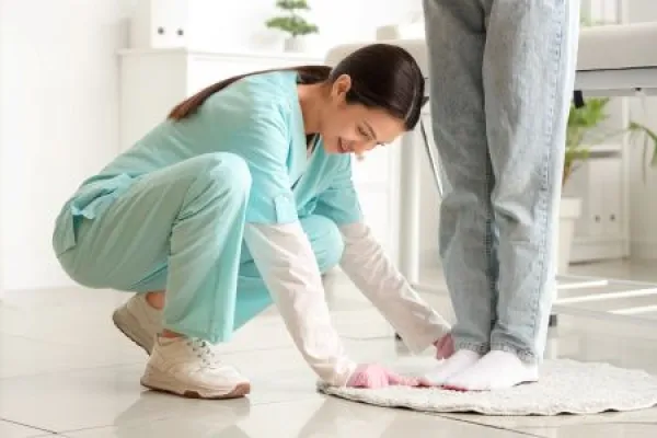 Female orthopedist trying insoles on patient's feet in clinic