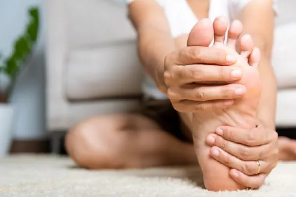 Foot pain, Asian woman feeling pain in her foot at home