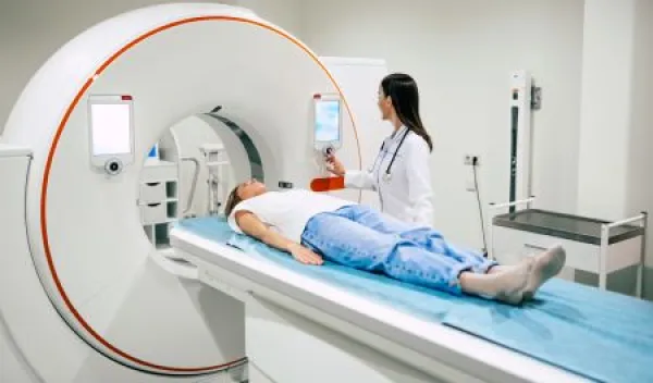 rofessional Doctor Radiologist In Medical Laboratory Controls magnetic resonance imaging or computed tomography or PET Scan with Female Patient Undergoing Procedure.