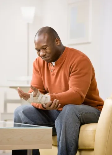 Frustrated man with splint in pain from injury to his wrist