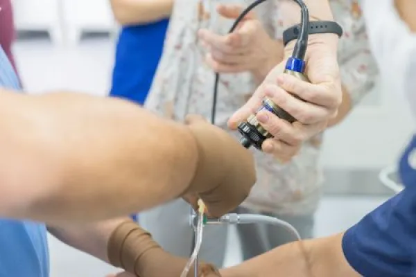 A team of urologist doctors performing a cystoscopy using a cystoscope.